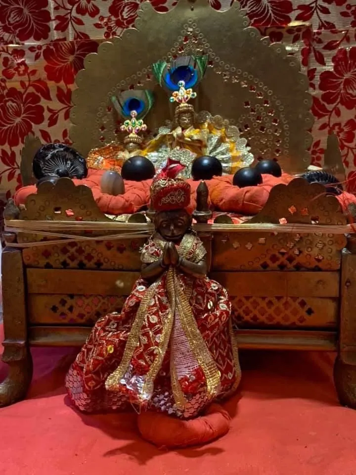 ठाकुर जी की वस्त्रों और मोरपंखों से सुसज्जित पूजा-वेदी