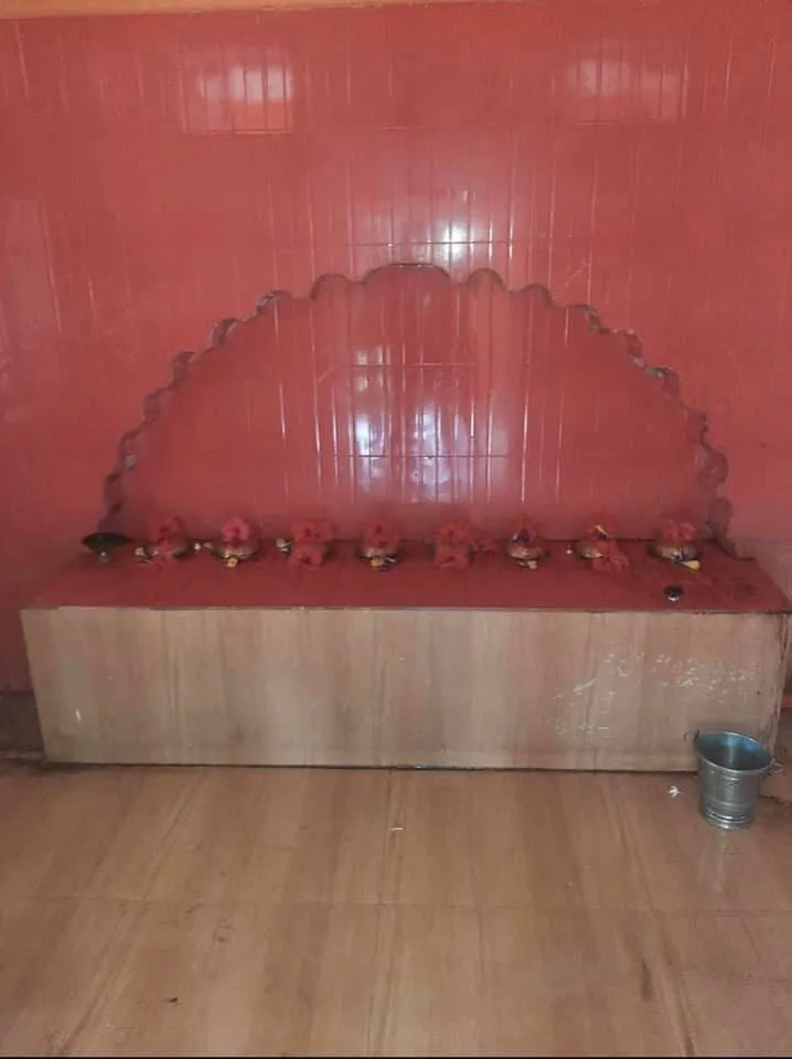 देवी स्थान में सिंदूर-लेपित छोटे विग्रह और पूजा-पात्र