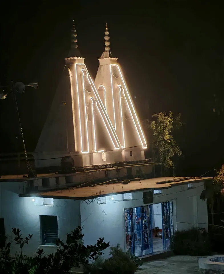 रात्रि में रोशनी से सजे जोड़ा मंदिर के दो शिखर और प्रवेश-द्वार